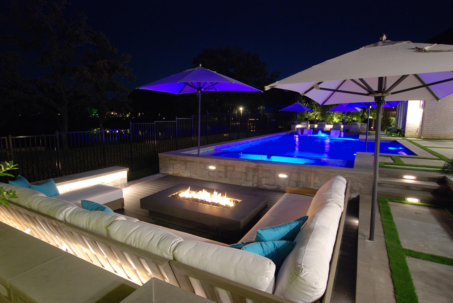 Modern pool courtyard with fire pit in Dallas by landscape design firm